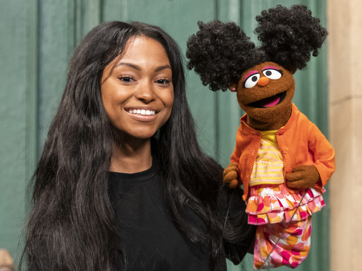 Megan Piphus Peace stands on the set of Sesame Street with her character, 6-year-old Gabrielle. Zach Hyman/Sesame Workshop