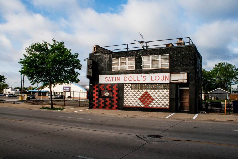 On the outside, the black-painted brick and checkered patterns of red, black, and white could leave someone dizzied, but the interior of Satin Doll’s Lounge did the opposite. Opened in 1977, the legendary jazz club owned by Minnette D. Wilson, known as “Satin Doll,” was a safe, invite-only haven in the heart of the city, located between 23rd and 24th Street on West Fond Du Lac Avenue. Described as elegant, and a beautiful dancer, Wilson, performed with legendary musician Duke Ellington and others. Wilson was Ellington’s muse for the hit song “Satin Doll” sung by Ella Fitzgerald. Wilson brought her personality to lounge, the inside was adorned with photos of Wilson and Duke Ellington, Milwaukee Police department patches, and stuffed animals. The downstairs party room was dedicated to Ellington and included a jukebox filled with his music. Creating Space in a Segregated City When Black musicians were still being discriminated against and not allowed in downtown venues, Satin Doll’s Lounge was a haven to escape to. Attracting both local and national talent, the lounge provided a place for Black musicians to perform in front of inclusive, integrated audiences. Often staying open until the sun came up, the lounge has been described at a non-rowdy place that had a nice social atmosphere. A sign on the door read, “You must be 38 years old or older to enter.” Due to its reputation for being safe and fun, and Wilson, having many connections with the Milwaukee Police Department, Satin Doll’s Lounge, made Milwaukee a true jazz destination for many. By the time of her death at age 79 in 2017, Satin Doll’s Lounge was closed, but Wilson left a rich legacy that continues to inspire today. Preserving Satin Doll’s History Many were able to experience what Satin Doll’s was firsthand, but for those who haven’t, there are groups working to preserve the history not only of the lounge, but also, the impact and contributions of Minnette Wilson to Milwaukee’s jazz scene. The Wisconsin Black Historical Society has documented and celebrated Wilson’s life and work. They have preserved photographs, posters, recordings of performances, and more to serve as a connection to the past and hopefully inspire the next generation. Satin Doll’s Lounge legacy remains strong today and demonstrates a beacon of hope and resiliency, that should be honored. Satin Doll Lounge