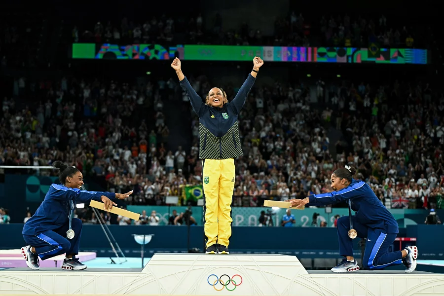 Simone Biles, left, joins teammate Jordan Chiles in pointing toward gold medalist Rebeca Andrade of Brazil. Biles won silver and Chiles bronze in the women's floor exercise at the Paris 2024 Olympic Games — the first time three Black athletes have shared the podium in Olympic gymnastics. Gabriel Bouys/AFP via Getty Images